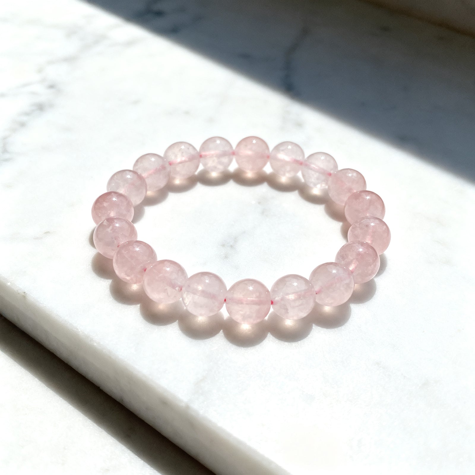 Rose Quartz beaded bracelet flat lay on calming background