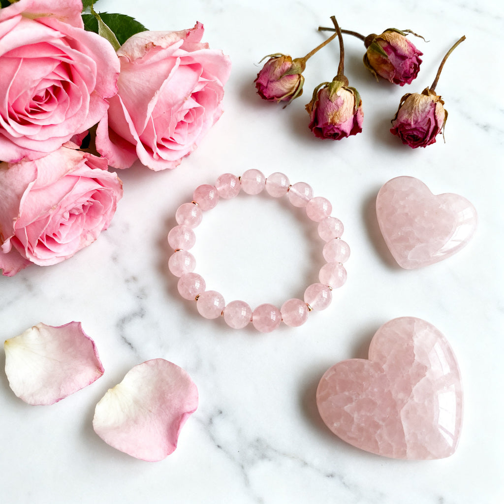 Rose Quartz bracelet flat lay with roses and crystals - love aesthetic composition